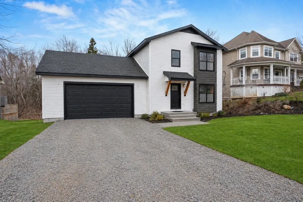 A Wildawbren finished suburban home with completed exterior siding, trim, and landscaping at handover